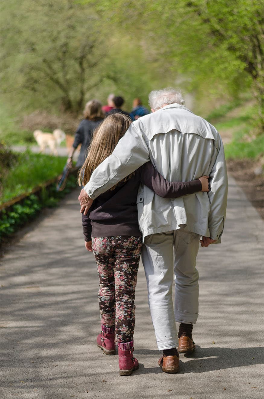 Older man walking with granddaughter
