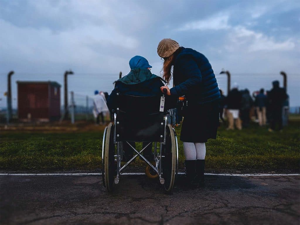 Gentleman in wheelchair outside with younger woman